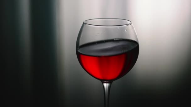 赤ワインがグラスに溢れています スポットライトの背景にあるグラスに天然ワイン グラスでアルコールドリンクカルスニー — ストック動画