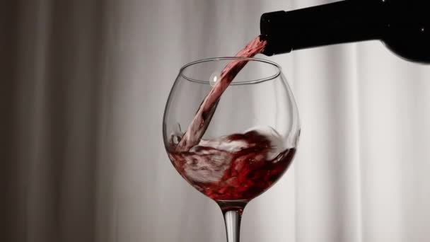 バーテンダーはボトルからグラスに赤ワインを注いでいます グレープワインをワイングラスに注ぐ グラスにワインのシルエット — ストック動画
