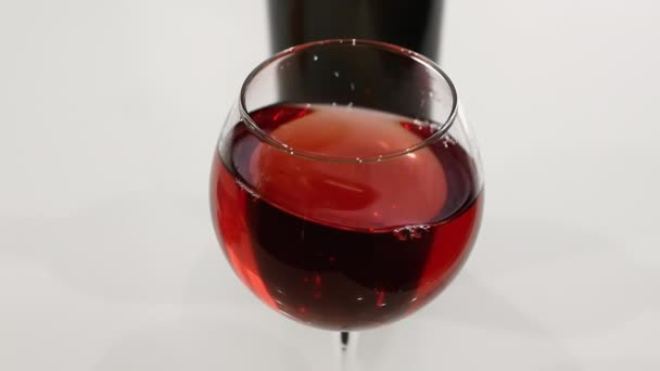 白いテーブルの上にグラスに赤ワイン ワイングラスでワインのトップビュー — ストック動画