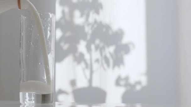 Susu Segar Dalam Gelas Transparan Dengan Latar Belakang Tirai Dapur — Stok Video