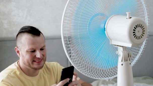 Gülümseyen Mutlu Yakışıklı Genç Adam Sıcak Havadan Kaçıyor Havalandırma Vantilatörü — Stok video