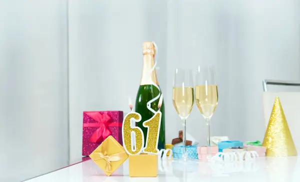 Date of birth with number  61. Festive Champagne in glasses with gift boxes, anniversary postcard. Happy birthday golden candles.