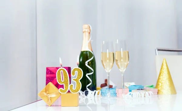 Date of birth with number  93. Festive Champagne in glasses with gift boxes, anniversary postcard. Happy birthday golden candles.