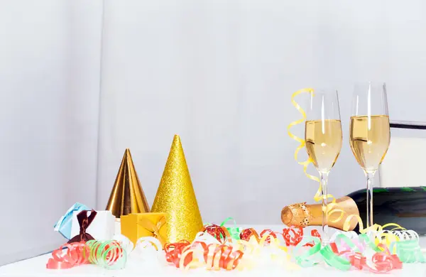 Date of Birth. Festive background with a bottle of champagne. Champagne in glasses with gift boxes, anniversary card, happy birthday decorations in white colors
