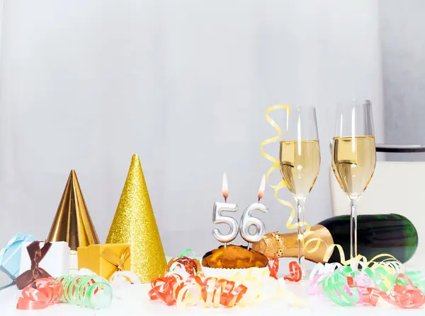 Date of Birth  56. Festive background with a bottle of champagne. Festive Champagne in glasses with gift boxes, anniversary card, happy birthday decorations in white colors