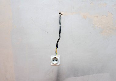 Antika bir Rosette, asılı bir rosette. Alçıdan elektrik kabloları, prizde kabloyla kabataslak kablolar.