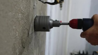  Tamirci, elinde matkapla duvarda bir oyuk açıyor. Daireye bir elektrik prizi kurulmuş. Çekirdek sondajları devam ediyor