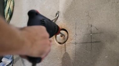 Becerikli bir adam, elinde matkapla çalışan bir erkek işçi için ağda delik açıyor. Daireye bir elektrik prizi kurulmuş. Çekirdek sondajları devam ediyor.