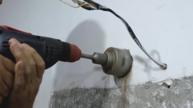 Becerikli bir adam, elinde matkapla çalışan bir erkek işçi için ağda delik açıyor. Daireye bir elektrik prizi kurulmuş. Çekirdek sondajları devam ediyor