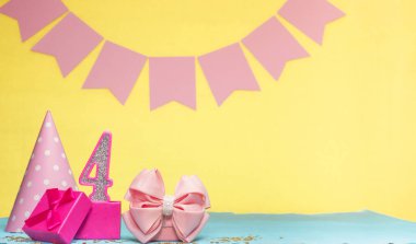 4 yaşındaki bir kızın doğum tarihi. Uzayı kopyala Sarı arkaplanlı pembe gözlüklü bir doğum günü. Üzerinde numaralandırılmış mumlar ve hediye kutusu olan dekorasyonlar. Bir kadın için yıldönümü kartı