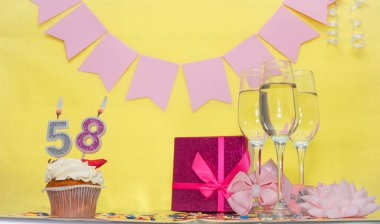 Doğum tarihi 58 numara. Mumlu puding turtası. Bir kız için mutlu yıllar. Pembe fiyonklu hediye kutusu. Yıl dönümü, kopyalama alanı