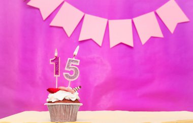 Doğum tarihi: 15 numara. Pembe arka plan, pasta ve yanan mumlar, yer ayırmak, bir kızın doğum günü için mutlu yıllar. Tatil pudingi..