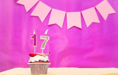 Geçmişi doğum tarihi 17 numara. Pembe arka plan, pasta ve yanan mumlar, yer ayırmak, bir kızın doğum günü için mutlu yıllar. Tatil pudingi..