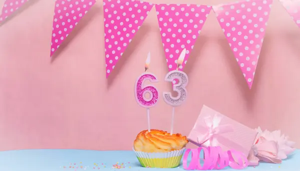 Date of Birth  63. Greeting card in pink shades. Anniversary candle numbers. Happy birthday girl, polka dot garland decoration. Copy space.