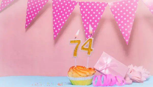 Date of Birth  74. Greeting card in pink shades. Anniversary candle numbers. Happy birthday girl, polka dot garland decoration. Copy space.