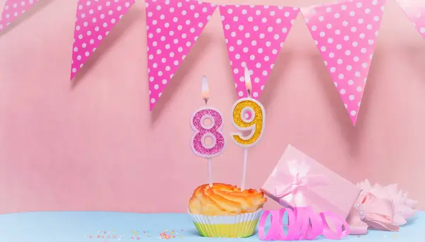 Date of Birth  89. Greeting card in pink shades. Anniversary candle numbers. Happy birthday girl, polka dot garland decoration. Copy space.
