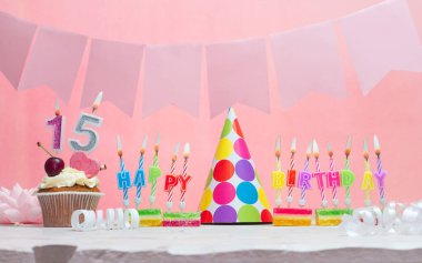 Doğum tarihi 15 'in geçmişi. Yıldönümü. Bir kız için mumlarla dolu güzel bir arka plan. Kadınların tebrik kartı. Pembeli mutlu yıllar..