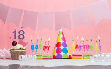 Doğum tarihi 18 'di. Yıldönümü. Bir kız için mumlarla dolu güzel bir arka plan. Kadınların tebrik kartı. Pembeli mutlu yıllar..