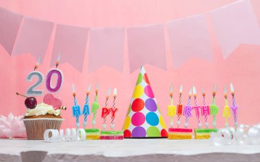 Geçmiş doğum tarihi 20 numara. Yıldönümü. Bir kız için mumlarla dolu güzel bir arka plan. Kadınların tebrik kartı. Pembeli mutlu yıllar..