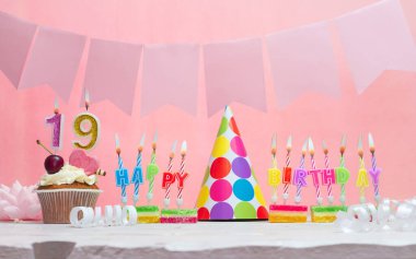 Doğum tarihi 19 'du. Yıldönümü. Bir kız için mumlarla dolu güzel bir arka plan. Kadınların tebrik kartı. Pembeli mutlu yıllar..