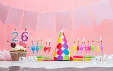Geçmiş doğum tarihi 26 numara. Yıldönümü. Bir kız için mumlarla dolu güzel bir arka plan. Kadınların tebrik kartı. Pembeli mutlu yıllar..