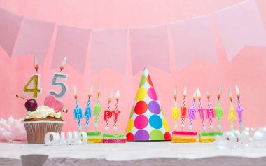 45 numaralı doğum tarihinin geçmişi. Yıldönümü. Bir kız için mumlarla dolu güzel bir arka plan. Kadınların tebrik kartı. Pembeli mutlu yıllar..