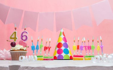 Geçmiş doğum tarihi 46 numara. Yıldönümü. Bir kız için mumlarla dolu güzel bir arka plan. Kadınların tebrik kartı. Pembeli mutlu yıllar..