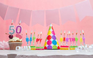 Geçmiş doğum tarihi 50 numara. Yıldönümü. Bir kız için mumlarla dolu güzel bir arka plan. Kadınların tebrik kartı. Pembeli mutlu yıllar..