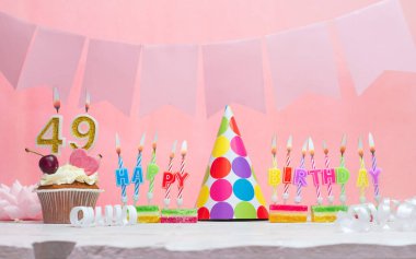 49 numaralı doğum tarihinin geçmişi. Yıldönümü. Bir kız için mumlarla dolu güzel bir arka plan. Kadınların tebrik kartı. Pembeli mutlu yıllar..