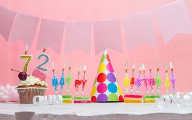 Geçmişi doğum tarihi 72. Yıldönümü. Bir kız için mumlarla dolu güzel bir arka plan. Kadınların tebrik kartı. Pembeli mutlu yıllar..