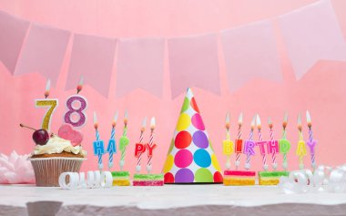 Geçmişi doğum tarihi 78. Yıldönümü. Bir kız için mumlarla dolu güzel bir arka plan. Kadınların tebrik kartı. Pembeli mutlu yıllar..