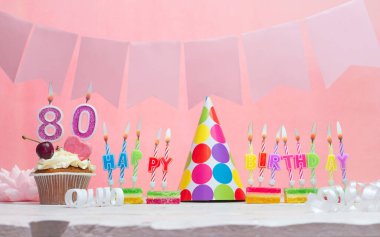 Doğum tarihi 80 'di. Yıldönümü. Bir kız için mumlarla dolu güzel bir arka plan. Kadınların tebrik kartı. Pembeli mutlu yıllar..