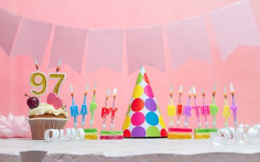 Geçmişi doğum tarihi 97. Yıldönümü. Bir kız için mumlarla dolu güzel bir arka plan. Kadınların tebrik kartı. Pembeli mutlu yıllar..