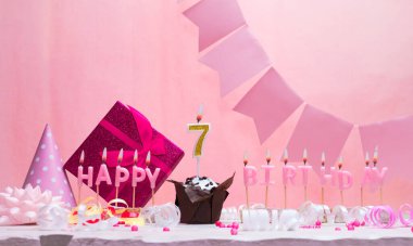 7 yaşındaki bir kızın geçmiş doğum tarihi. Yıldönümü. Mumlarla dolu güzel bir arka plan. Pastayla birlikte kadınların tebrik kartı. İyi ki doğdun. Boşluğu kopyala