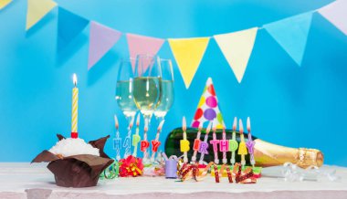 Doğum tarihi, mum kelimelerle. Yıldönümü kartı ve şampanya. Tatil süslemeleri. Mutlu doğum günü mumları. Çok renkli çelenklerle süslenmiş.