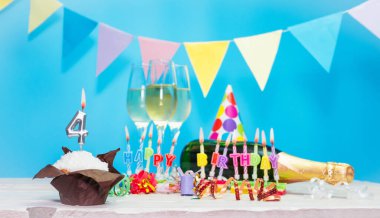 Doğum tarihi, mumlar ve 4 numara. Yıldönümü tebrik kartı. Tatil süslemeleri. Mutlu doğum günü mumları. Çok renkli çelenklerle süslenmiş.