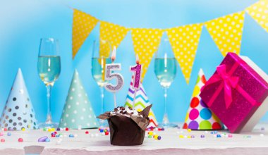 Doğum günü kutulu bir kadın ya da kız için doğum tarihi. 51 numaralı mumlu turta. Yıldönümü kartı ve şampanya. Tatil süslemeleri. Mutlu yıllar.