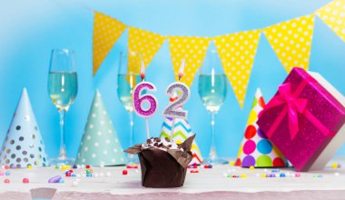 Doğum günü kutulu bir kadın ya da kız için doğum tarihi. 62 mumlu turta. Yıldönümü kartı ve şampanya. Tatil süslemeleri. Mutlu yıllar.