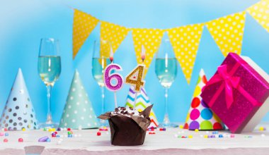 Doğum günü kutulu bir kadın ya da kız için doğum tarihi. 64. mumlu turta. Yıldönümü kartı ve şampanya. Tatil süslemeleri. Mutlu yıllar.