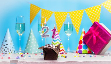 Doğum günü kutulu bir kadın ya da kız için doğum tarihi. 21 mumlu turta. Yıldönümü kartı ve şampanya. Tatil süslemeleri. Mutlu yıllar.