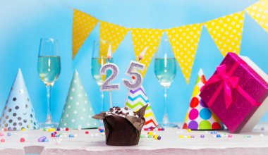 Doğum günü kutulu bir kadın ya da kız için doğum tarihi. Mum sayısı 25 olan turta. Yıldönümü kartı ve şampanya. Tatil süslemeleri. Mutlu yıllar.
