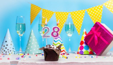 Doğum günü kutulu bir kadın ya da kız için doğum tarihi. 28 mumlu turta. Yıldönümü kartı ve şampanya. Tatil süslemeleri. Mutlu yıllar.