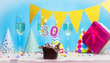 Doğum günü kutulu bir kadın ya da kız için doğum tarihi. Mum sayısı 30 olan turta. Yıldönümü kartı ve şampanya. Tatil süslemeleri. Mutlu yıllar.