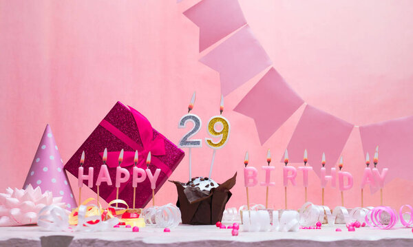 Background card date of birth for a girl  29. Anniversary. Beautiful festive background with candles. Women's congratulations card with a cake. Happy birthday in pink. copy space