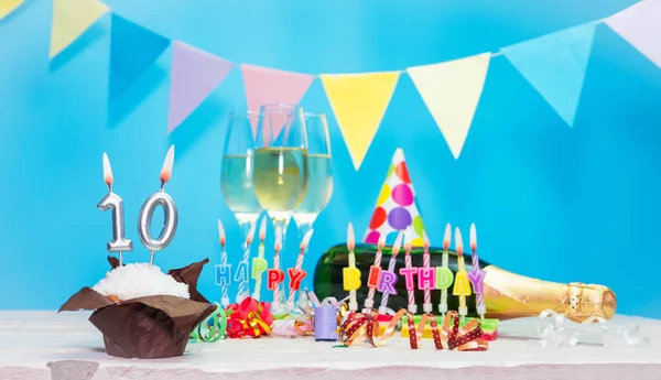 Doğum tarihi, mumlar ve 10 numara. Yıldönümü tebrik kartı. Tatil süslemeleri. Mutlu doğum günü mumları. Çok renkli çelenklerle süslenmiş.