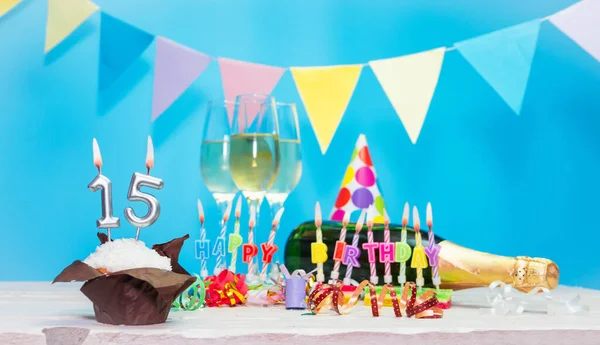 Doğum tarihi, mumlar ve 15 numara. Yıldönümü tebrik kartı. Tatil süslemeleri. Mutlu doğum günü mumları. Çok renkli çelenklerle süslenmiş.
