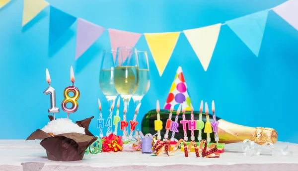 Doğum tarihi, mumlar ve 18 numara. Yıldönümü tebrik kartı. Tatil süslemeleri. Mutlu doğum günü mumları. Çok renkli çelenklerle süslenmiş.