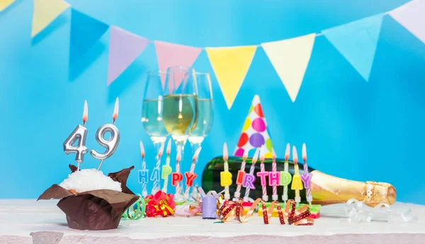 Doğum tarihi, mumlar ve 49 numara. Yıldönümü tebrik kartı. Tatil süslemeleri. Mutlu doğum günü mumları. Çok renkli çelenklerle süslenmiş.
