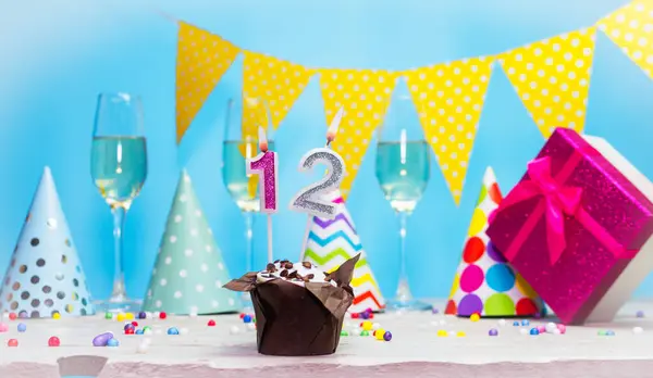 Doğum günü kutulu bir kadın ya da kız için doğum tarihi. 12 mumlu turta. Yıldönümü kartı ve şampanya. Tatil süslemeleri. Mutlu yıllar.