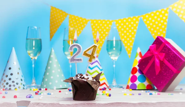 Doğum günü kutulu bir kadın ya da kız için doğum tarihi. 24 mumlu turta. Yıldönümü kartı ve şampanya. Tatil süslemeleri. Mutlu yıllar.